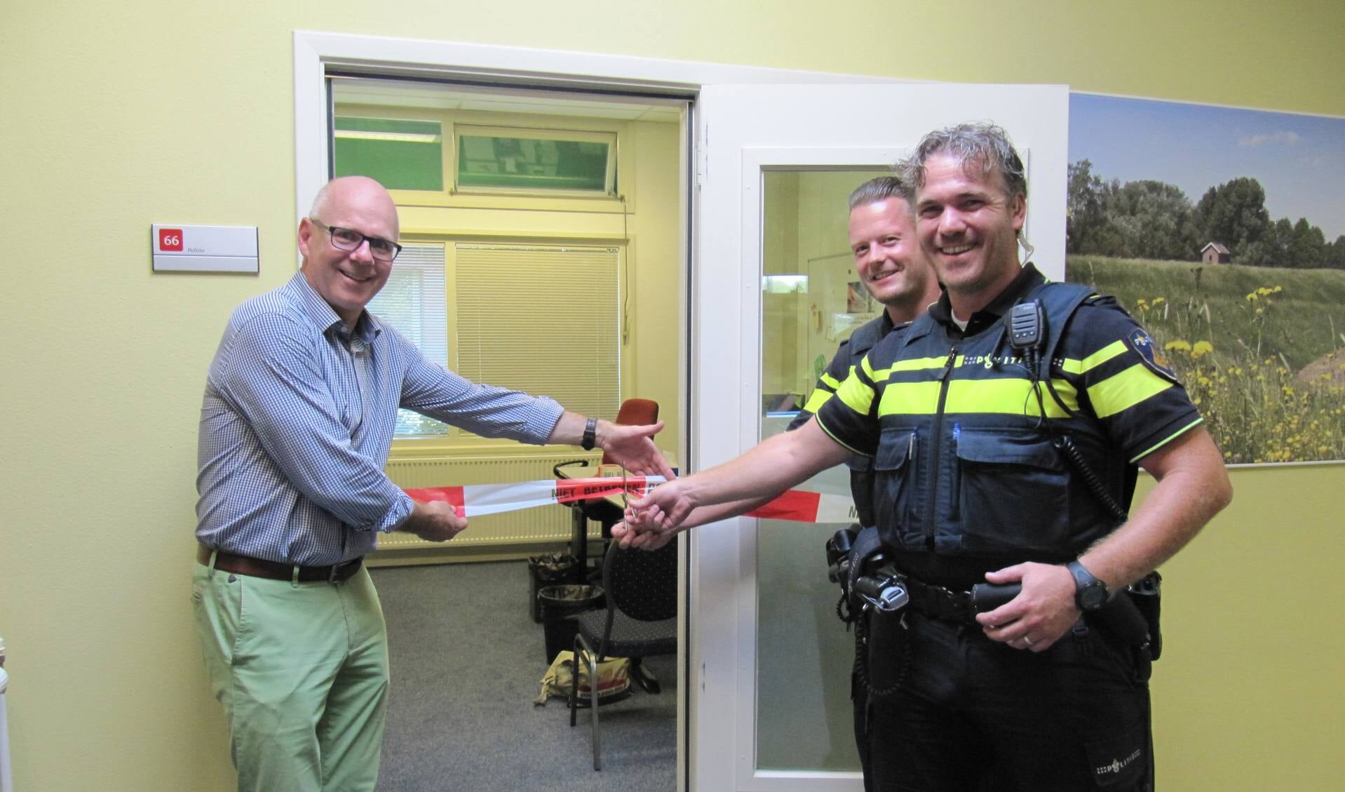 Burgemeester Carol van Eert (links) opent het politiesteunpunt samen met wijkagenten Freek Kleinschiphorst en Martijn Goppel.