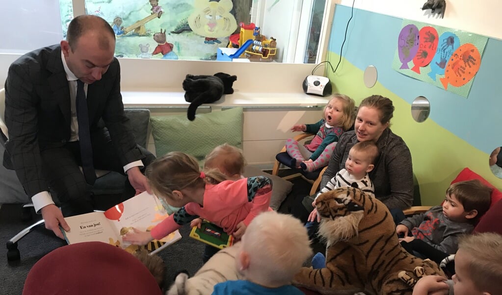 Burgemeester Vincent van Neerbos leest voor aan kinderen bij KDV Hummeltjeshof.