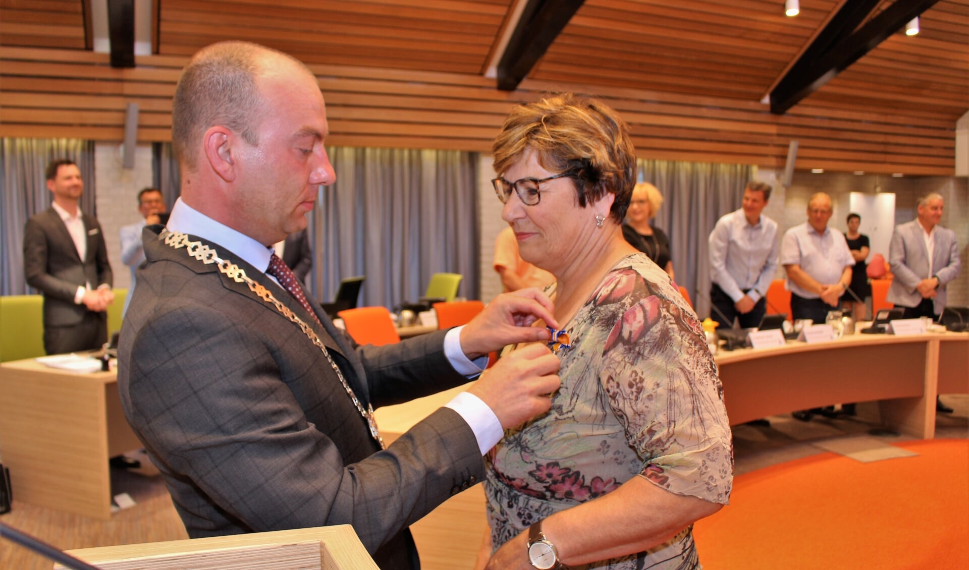 Burgemeester van Neerbos reikt de versierselen uit. 