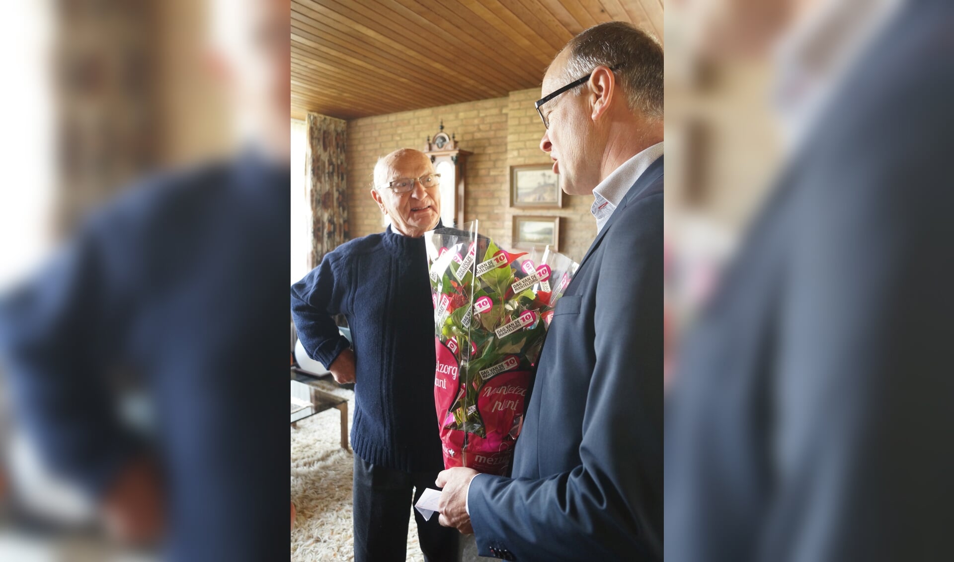 De heer Van Toor is verrast dat wethouder Geert Hendriks hem een bloemetje komt brengen.