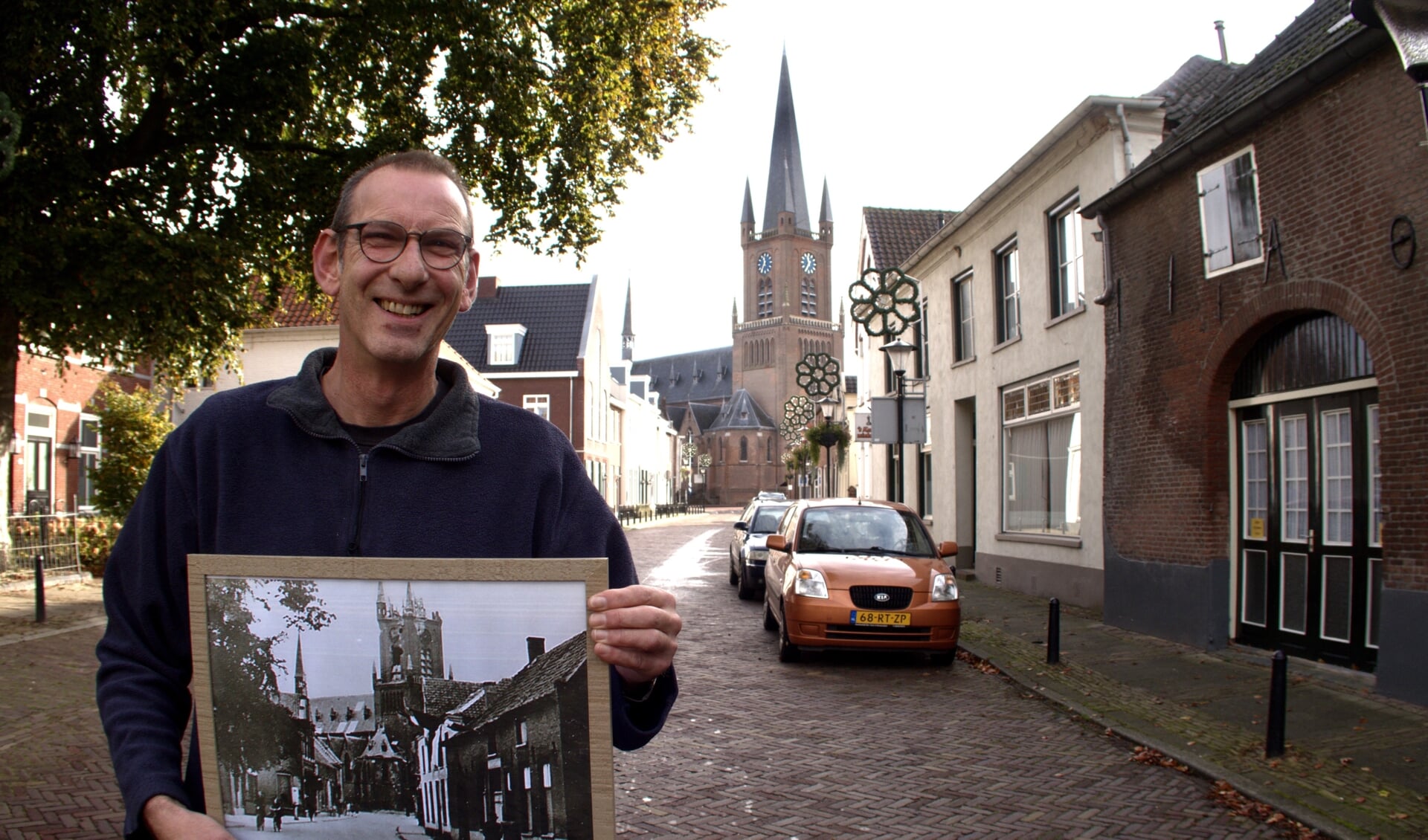 Antoon Hol met een foto uit 1945 van de kapotgeschoten kerk.