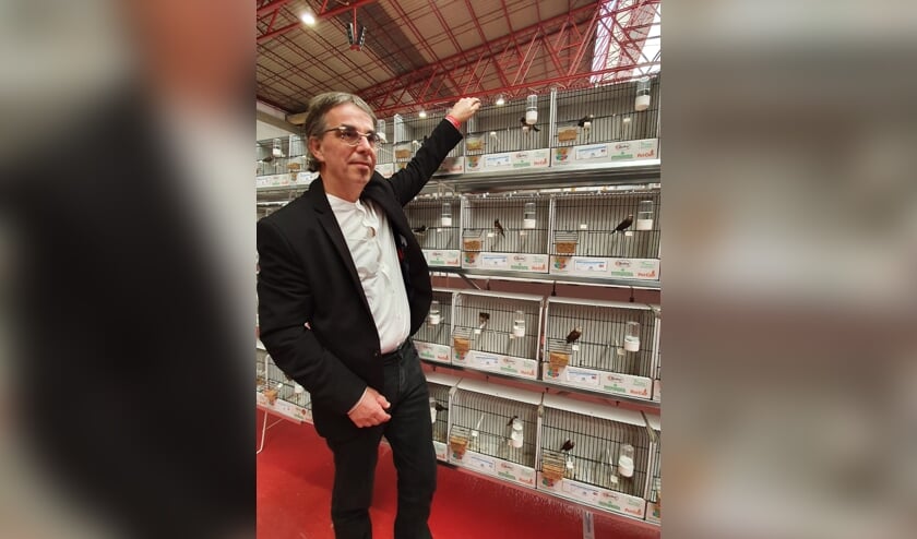 De trotse winnaar bij zijn gouden vogels.