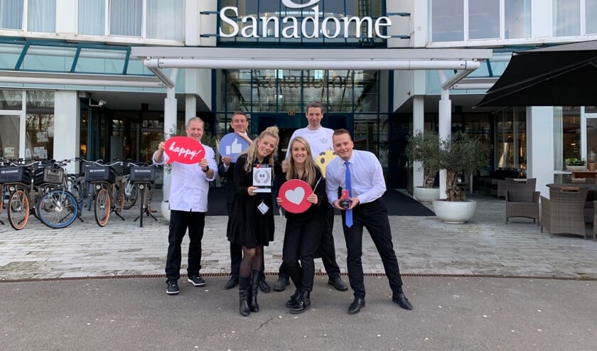 Trotse team members van Sanadome poseren met de award voor de ingang van het wellnesshotel.