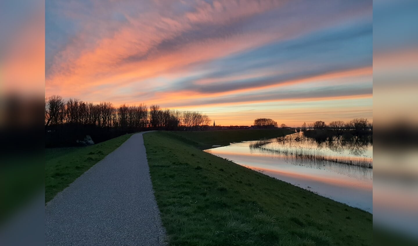 Zonsondergang op de dijk in Maas en Waal