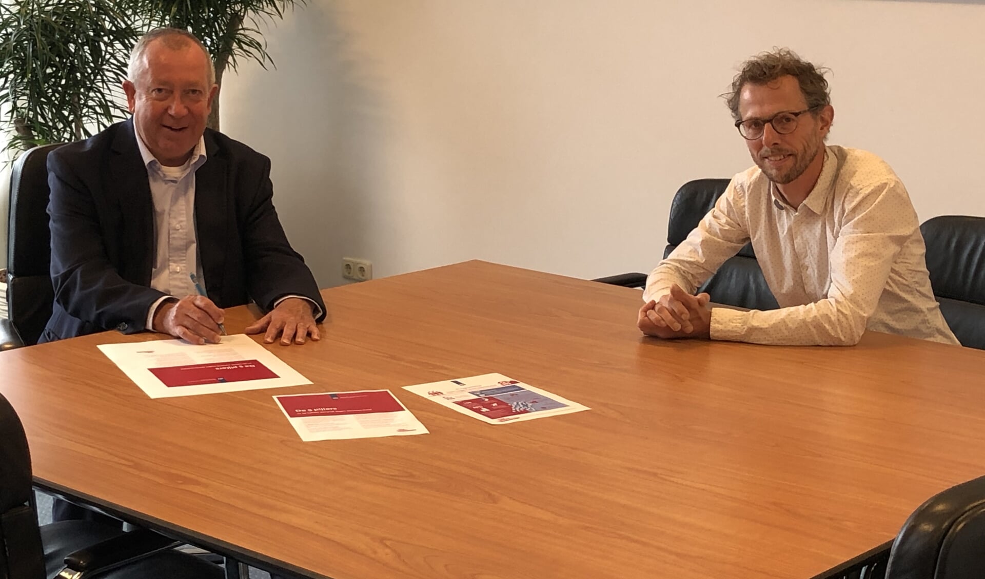 Wethouder Sjef van Elk tekent, samen met Daan de Bruijn van het
actieprogramma, het convenant Eén tegen eenzaamheid.