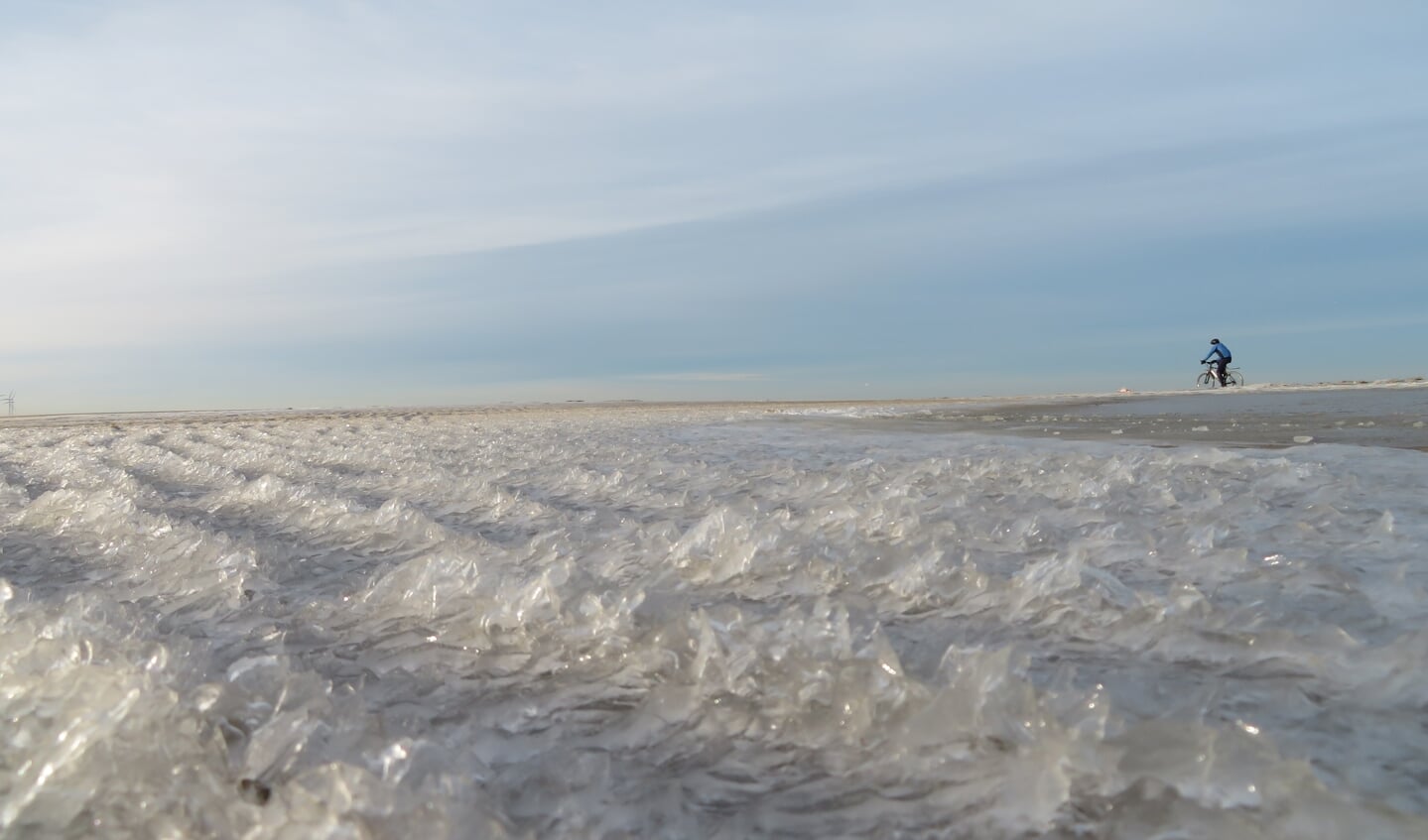 Prachtig bevroren strand en een mountainbiker die mijn beeld in fietst.