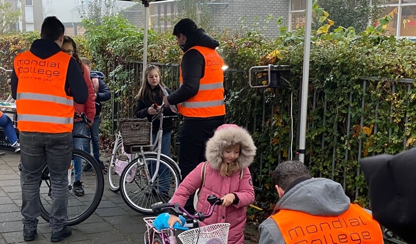 Leerlingen van het Mondial College Nijmegen controleren fietsverlichting.   