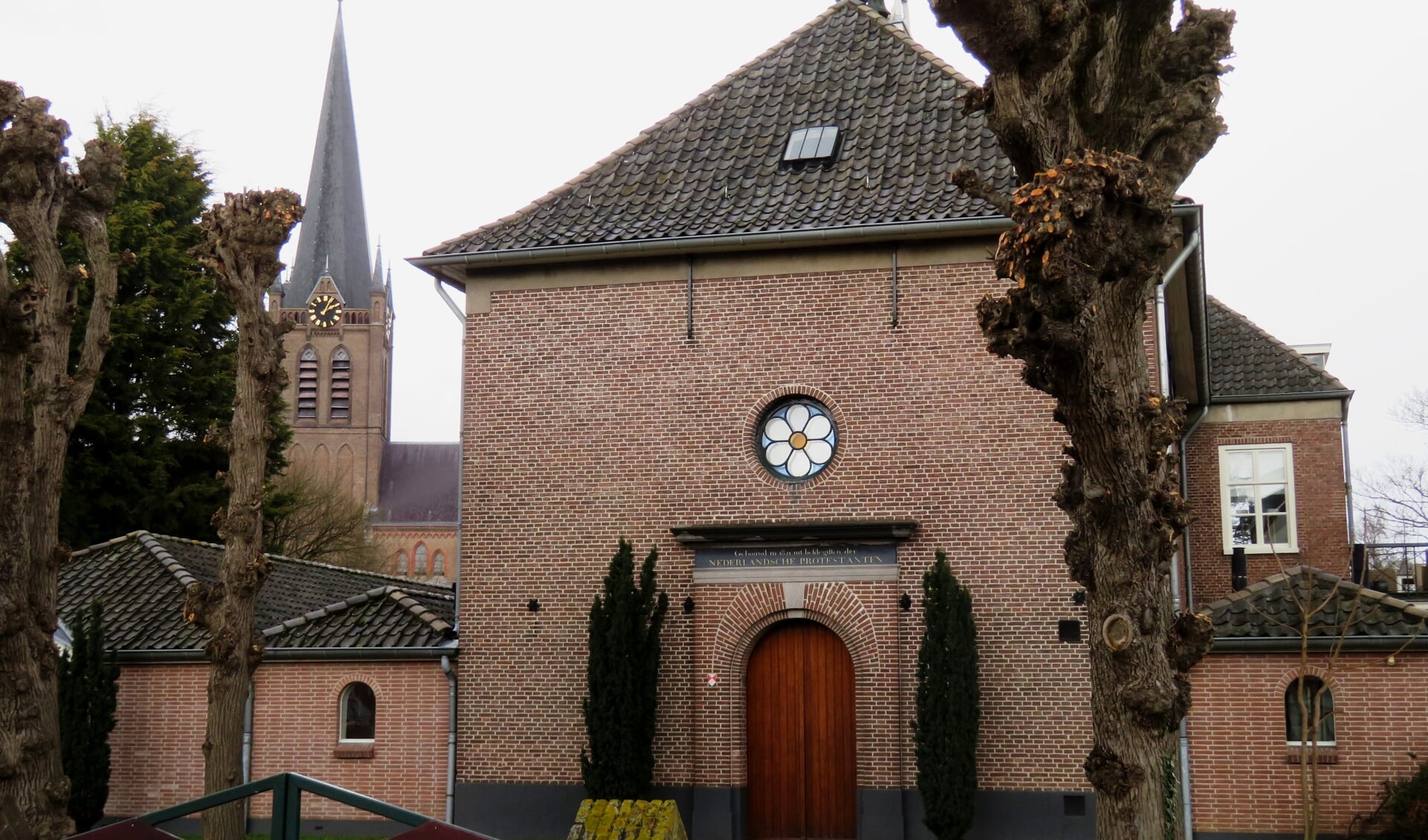 Protestantse kerk in Beuningen met de RK kerk op de achtergrond.