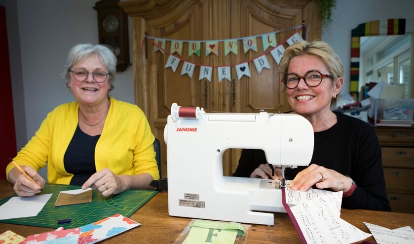 <p>Irma Botter (links) en Hellen Verhees maken vlaggenlijnen.</p>