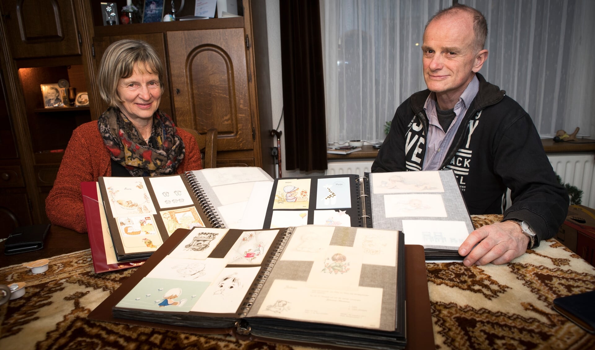 Elly en Wilbert Smits met de verzameling geboortekaartjes van hun overleden moeder. 