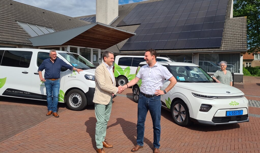 Directeur Geert Eikhout van Personenvervoer Maas en Waal en wethouder Rob Reuvers en  voor de nieuwe elektrische voertuigen.