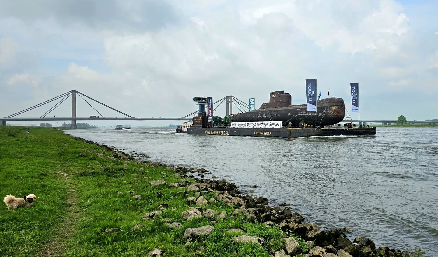 Vervoer van een Duitse onderzeeboot over de Waal, met op de achtergrond de PWA-brug in Beneden-Leeuwen.