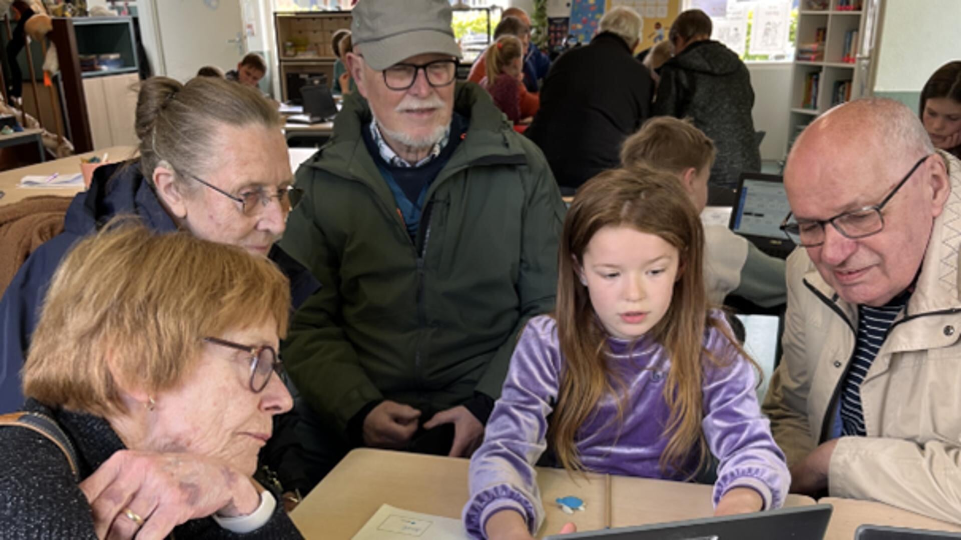 Yarah laat haar Opa's en Oma's zien hoe er op het Chromebook gewerkt wordt.