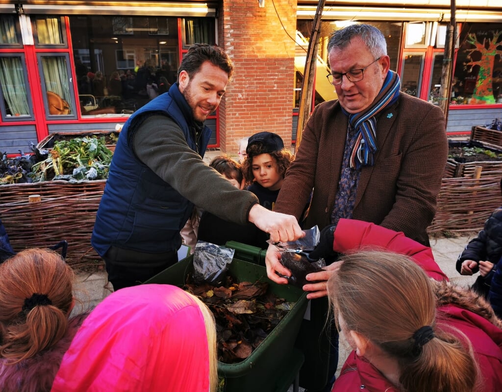 Wethouder Piet de Klein (rechts) met kinderen bij opening wormenhotel MKC Montijn