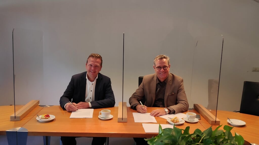 Cees den Otter, directeur bij Aannemersbedrijf P. van Leeuwen (l) en Marinus Kempe, directeur-bestuurder van De Kernen (r) tekenen samen de aannemingsovereenkomst