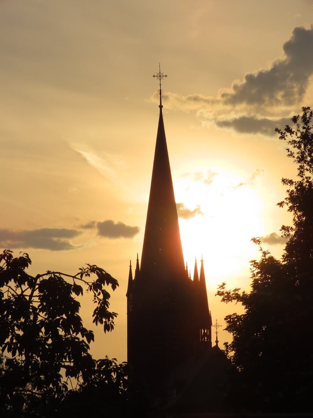 De Cornelius kerk in Beuningen met lage zon erachter.