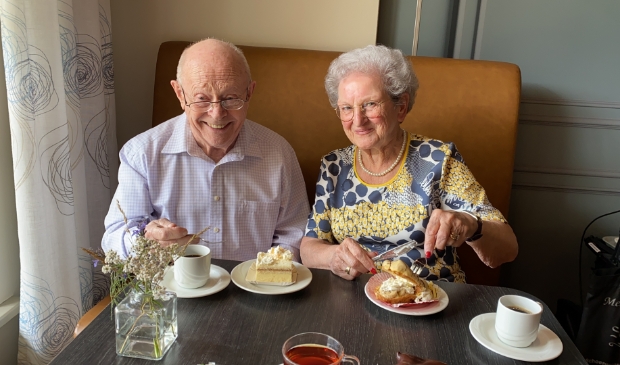 <p>Willy (l) en Diny (r) eten samen met zichtbaar genoegen gebak.</p>