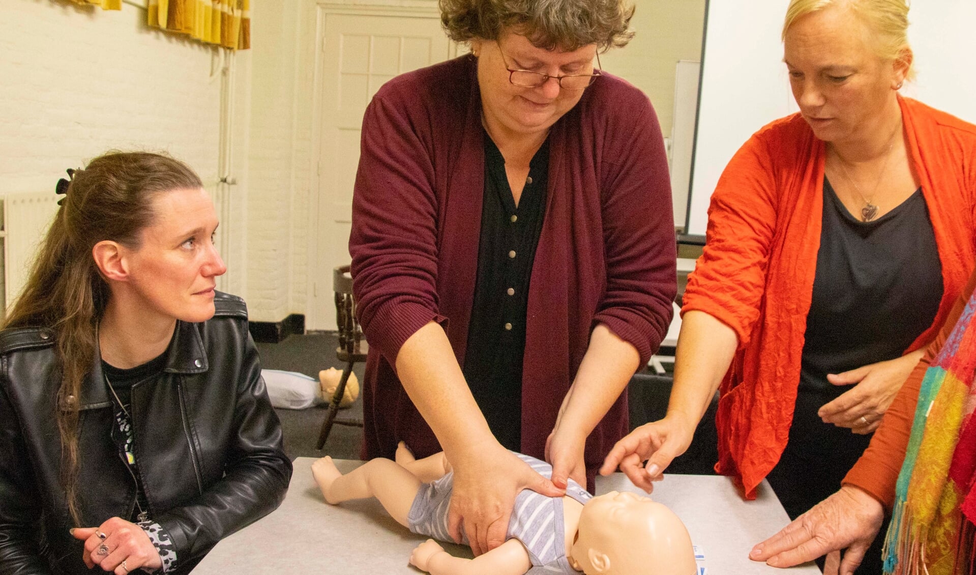 Marion van Oers (rechts) legt uit hoe de baby te reanimeren.