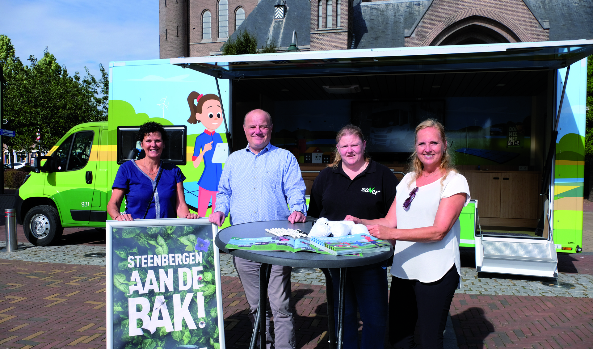 Foto: wethouder Maurice Remery en beleidsmedewerker Carien Free (rechts op de foto) met twee voorlichtingsmedewerkers van Saver. Zij promoten in inzamelen van restafval via Saver met de slogan 'Steenbergen aan de Bak!'