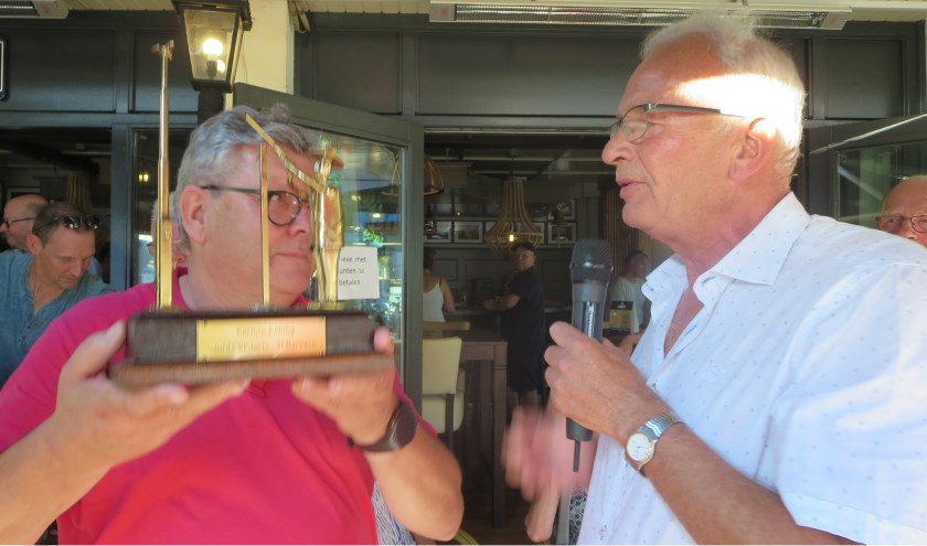 Willie Reinders neemt de wisseltrofee in ontvangst.