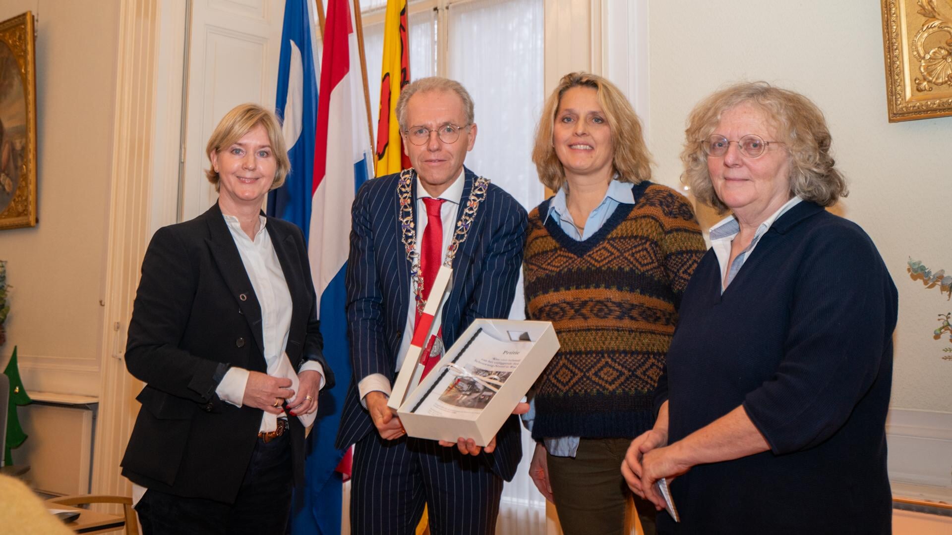 De initiatiefnemers (vlnr) Monique Rueb, Françoise van Leeuwen en Jos O’Herne overhandigen de petitie aan burgemeester De Lange.