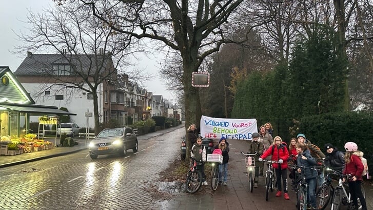 De initiatiefnemers van de petitie voor het behoud van het fietspad met een groep schoolkinderen.