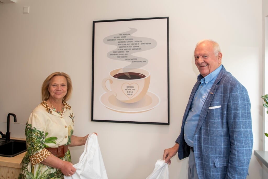 Wethouder Inge Zweerts de Jong en André van Herk, voorzitter De Stille Kracht, onthullen het kunstwerk in de nieuwe koffiecorner van de Kringloopwinkel. Foto: René de Wit.