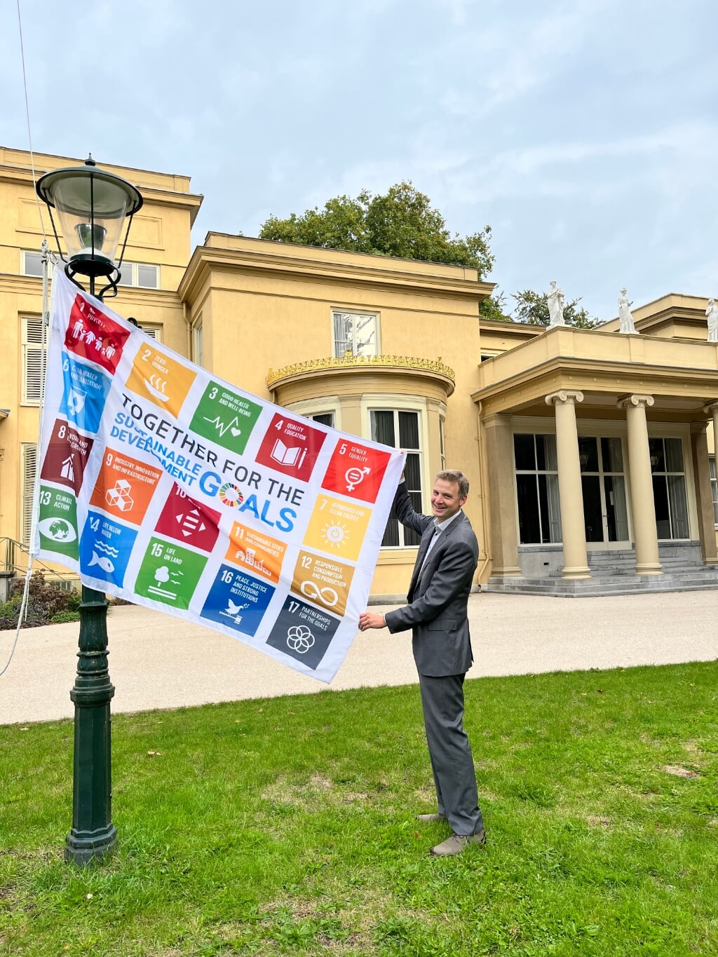 SDG vlag wordt gehesen door de wethouder Aart van Sloten bij de Raadhuis De Paauw