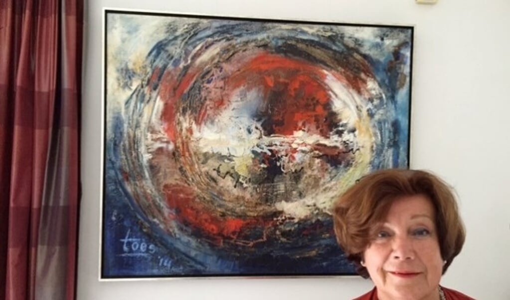 Toos Boekhoven thuis voor haar schilderij 'Wereld in verwarring.'