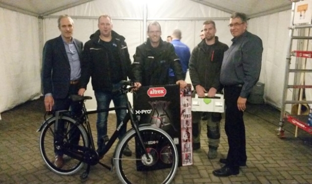 Steven Burghouwt (links) en Karel Oostendorp (rechts) overhandigen prijzen aan gasten van het 40-jarig jubileumfeest. Foto: Rick Praamstra