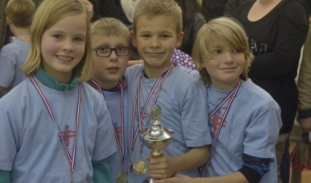 Vera Schutyser, Tim Verwoert, Wisse Langstraat en Frank de Bruijn (v.l.n.r.) bejubelen de titel bij de welpen van de Johan Frisoschool. Foto: Jaap Mons