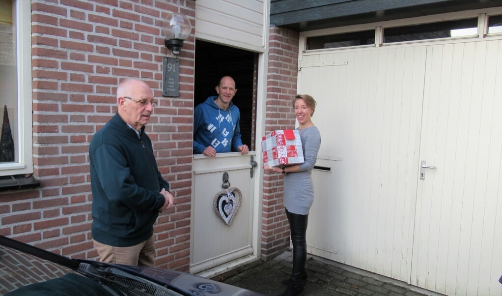 Theo Vertelman en Martina Mens bezorgen een pakket bij Koos Slippens, vrijwilliger bij onder andere Hoeve Engelenburgh.