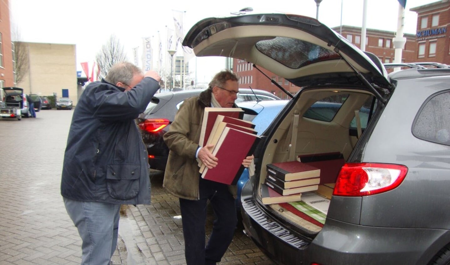 Hans van der Beek legt de mappen in de auto.