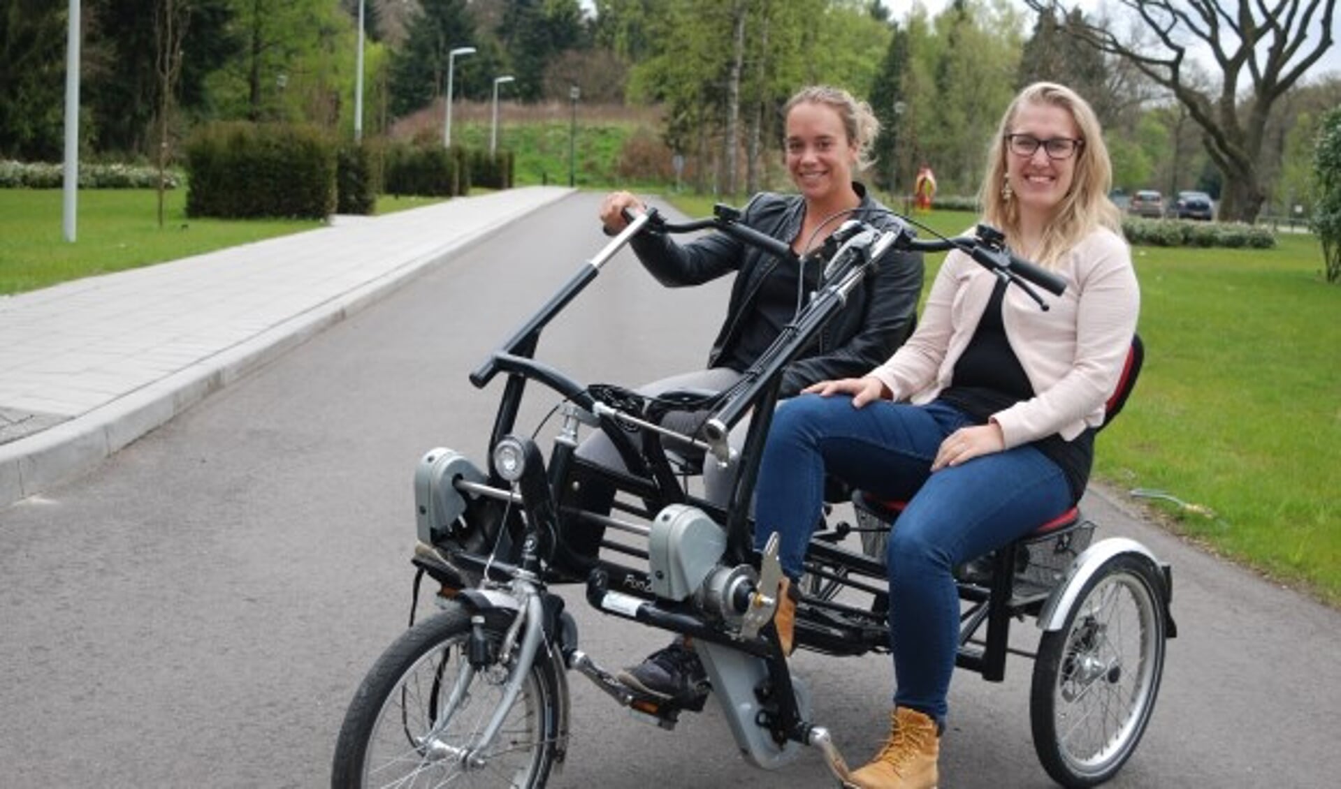 Anne Stellaard (links) en Mylène Mosterd op een duofiets. ''We zoeken nog vrijwilligers die onder meer samen met een bewoner op een van de tien duofietsen een gezamenlijk fietstochtje willen maken.''