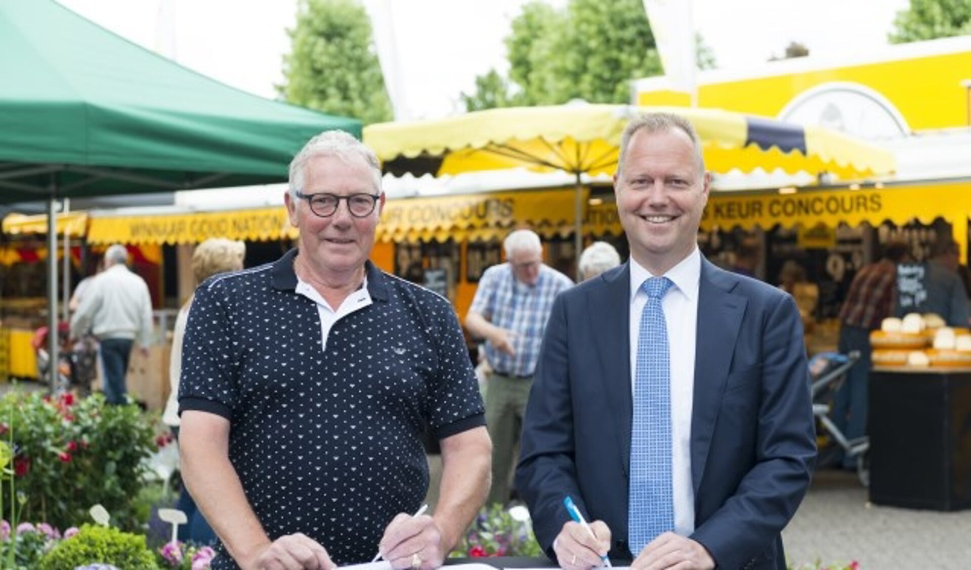 Wethouder Engbert Stroobosscher en Hans Middelhoven, voorzitter van de Stichting Markt Veenendaal, ondertekenen de overeenkomst.