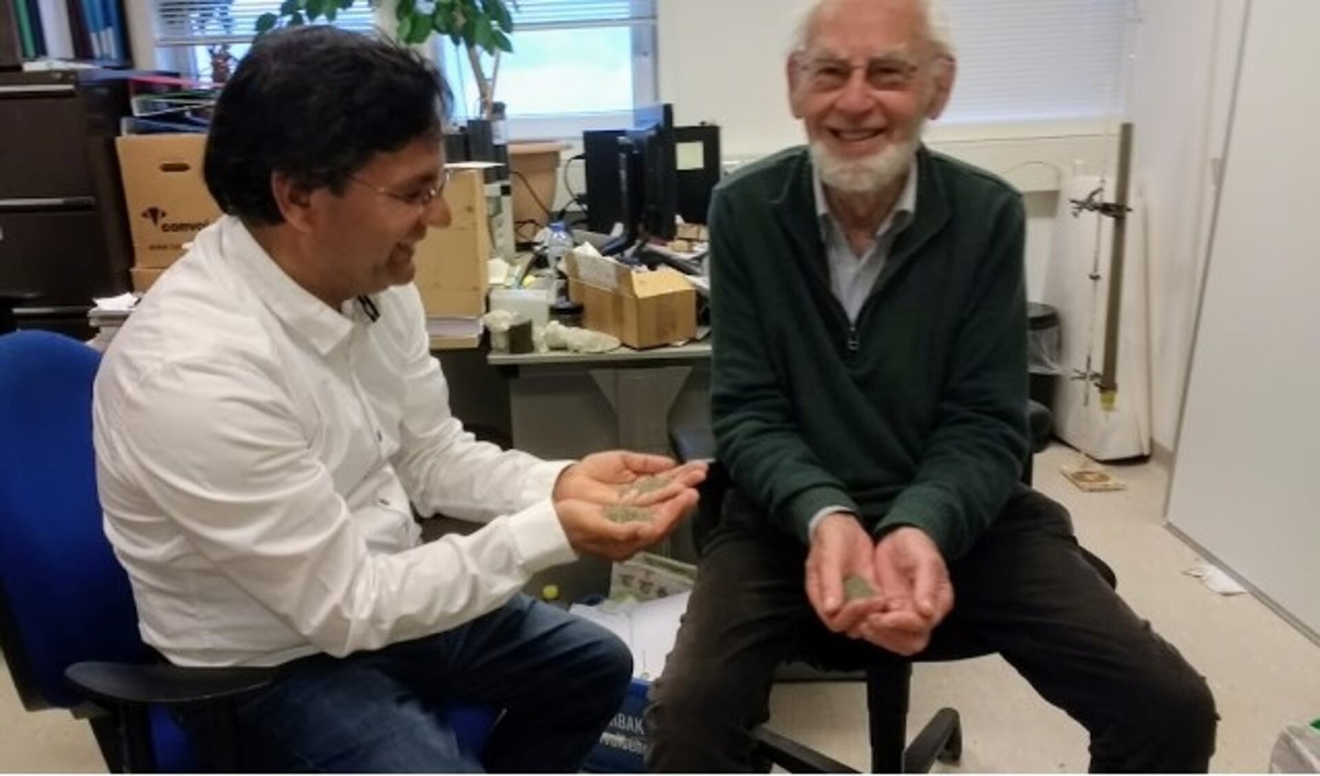 Professor Schuiling (rechts) en Nasir Javid met olivijn. Als gastonderzoeker is Schuilling (85) nog steeds actief.