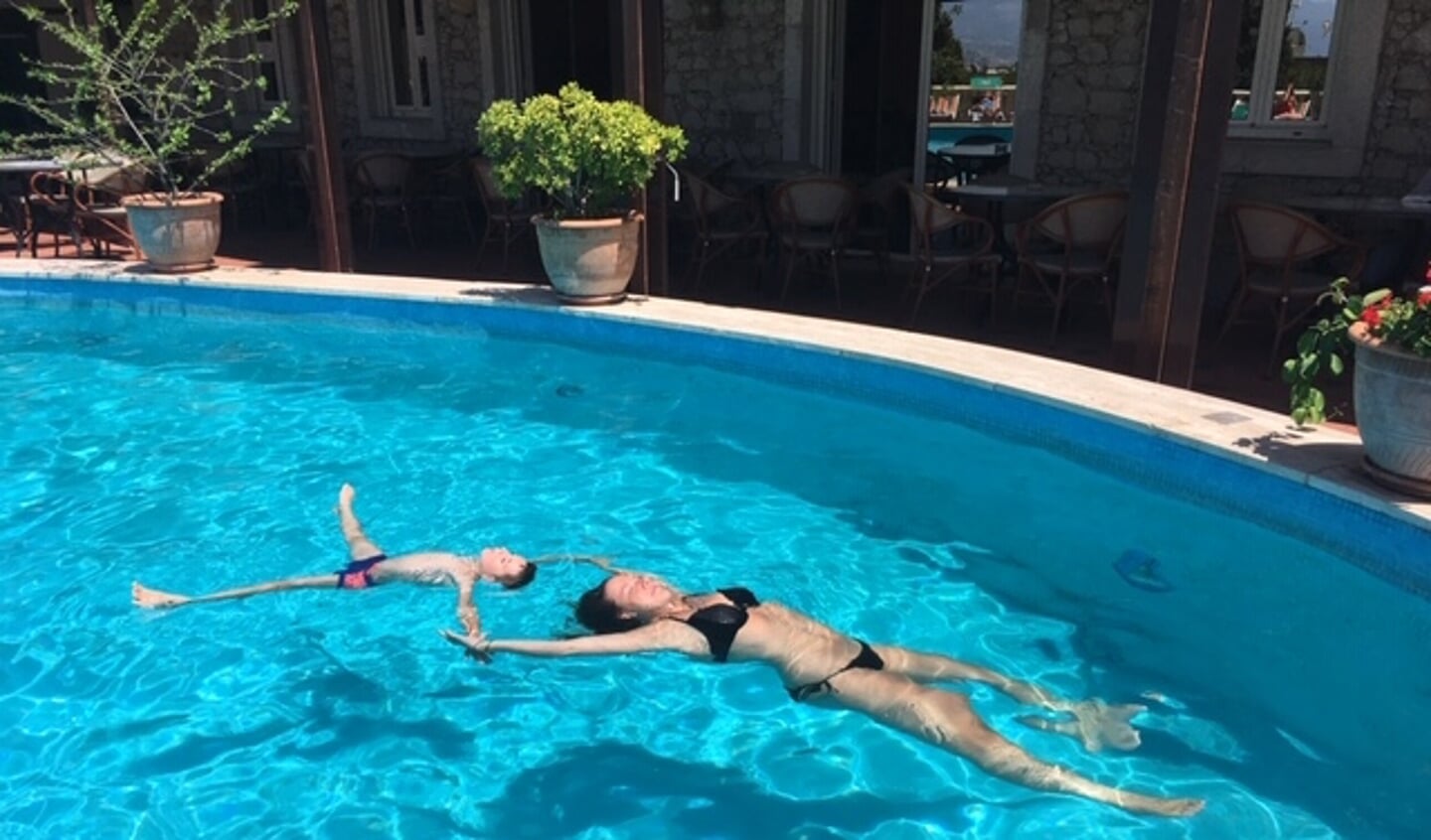 Kleindochter en kleinzoon genieten in het zwembad in Taormina. 