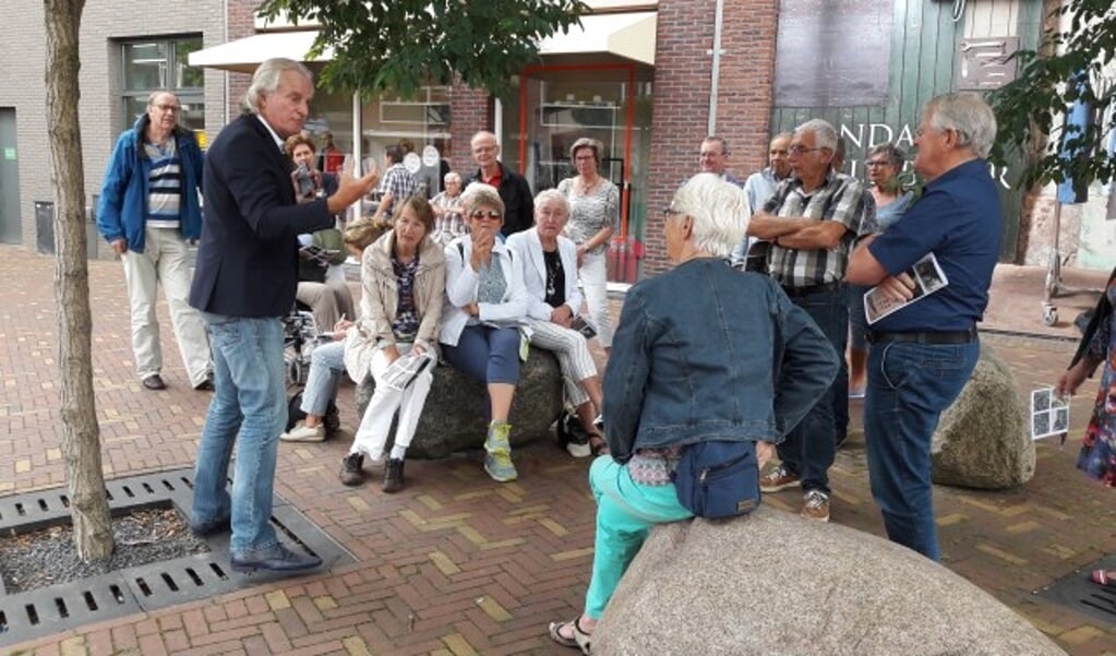 Stadsgids Jaap Pilon was donderdag weer op dreef. Hij leidde een groep van ruim 20 personen rond en vertelde allerlei details over de plek waar men stond, zoals hier op het Zwaaiplein nabij de Brouwersgracht. (Foto: Martin Brink/Rijnpost)
