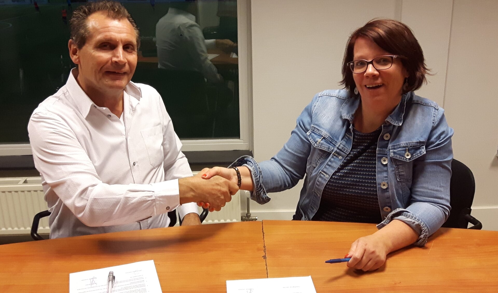 De voorzitters van Handbal Houten en FC DElta '95 bezegelen de overeenkomst