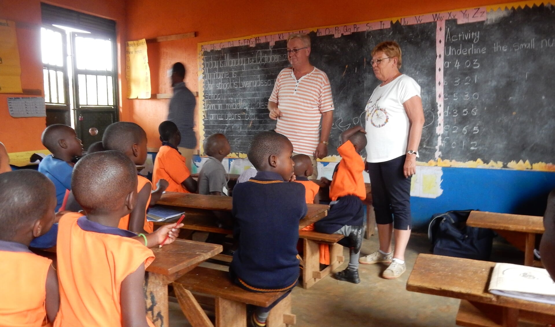 Pieter en Marga Streefkerk voor de klas in de Lwerudeso school in Lwengo, Uganda.