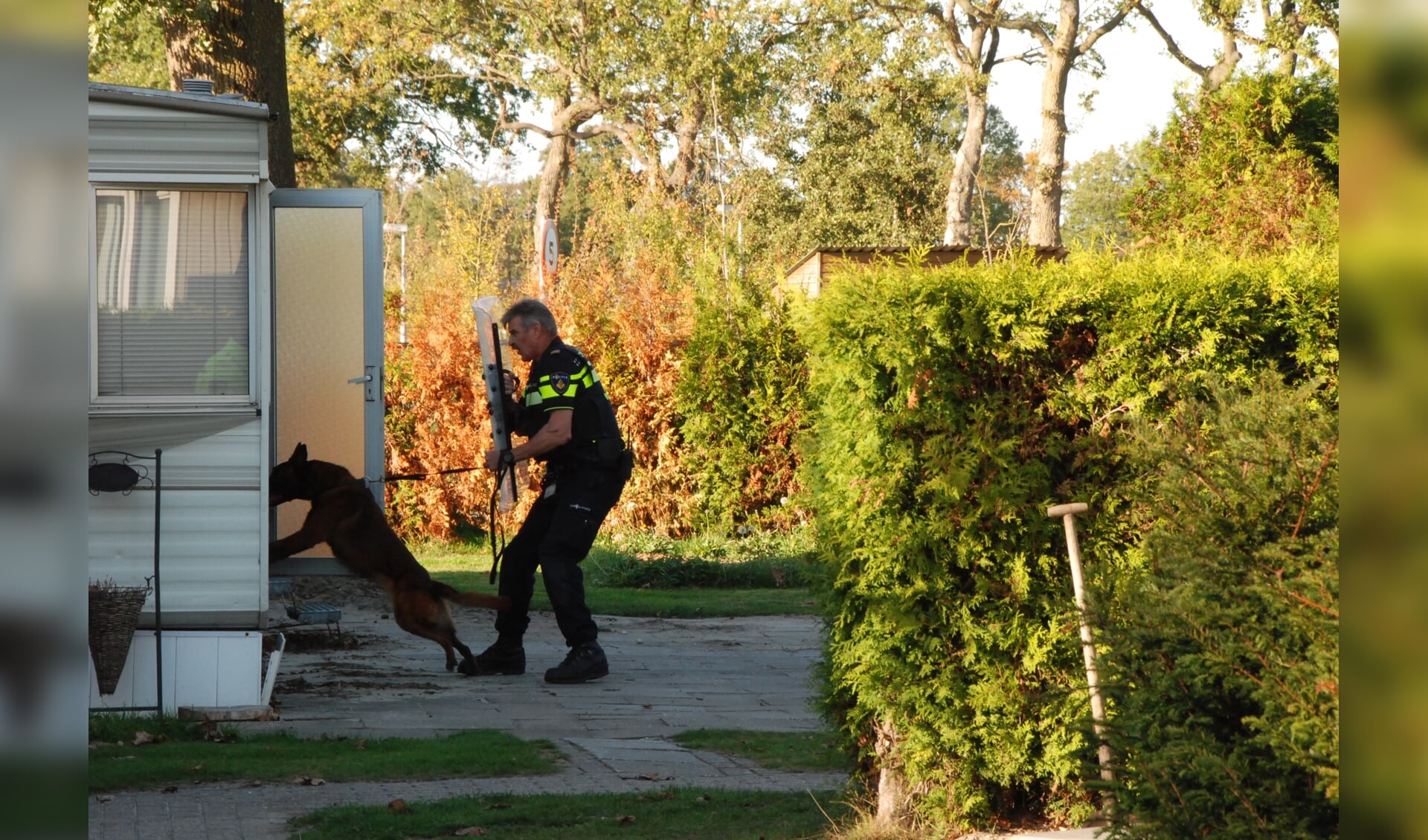 De politiehond wordt ingezet om de tweede verdachte uit de caravan te krijgen.