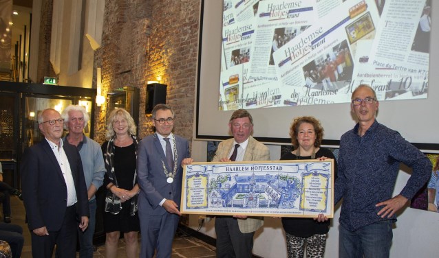 Burgemeester Wienen neemt het tegeltableau in ontvangst.