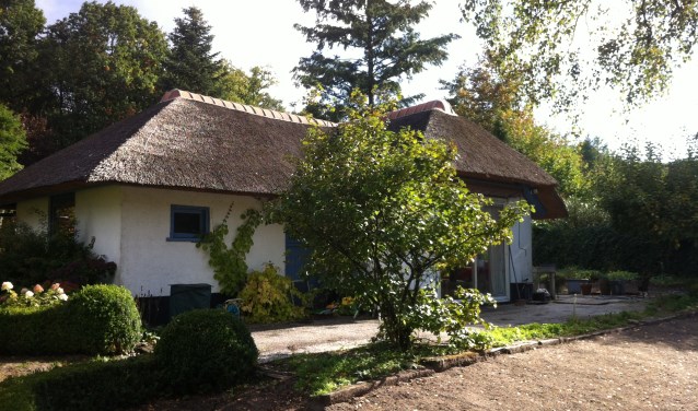 Eén van de woningen op Nieuw Wildenburg in de kenmerkende stijl: wit met een rieten dak met een gemetselde pannennok.