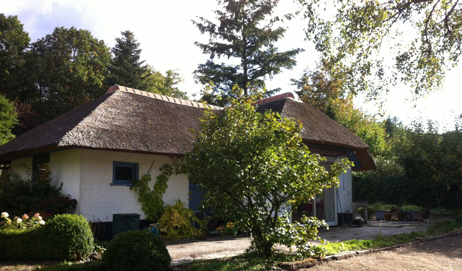 Eén van de woningen op Nieuw Wildenburg in de kenmerkende stijl: wit met een rieten dak met een gemetselde pannennok.