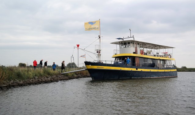 Safarischip De Blauwe Bever legt aan bij een krib in de Neder-Rijn bij Wageningen.