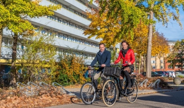 Burgemeester Sjoerd Potters en Jessie Bekkers-Van Rooij (SSW) op de fiets in de Kometenlaan