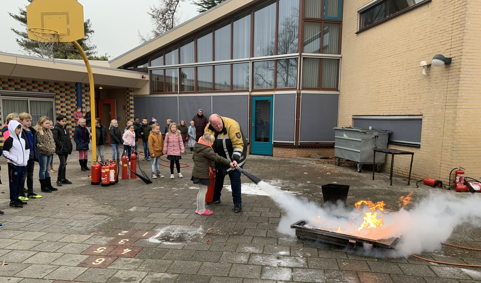 Koepelschoolkinderen leren brandjes te blussen.