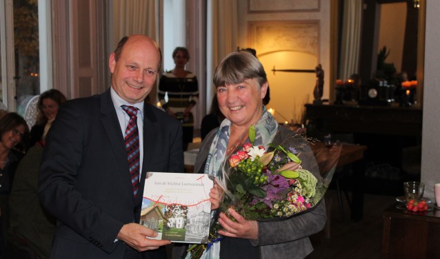Loco-burgemeester Rob Jorg neemt het eerste exemplaar van het boek in ontvangst uit handen van auteur Annet Werkhoven.