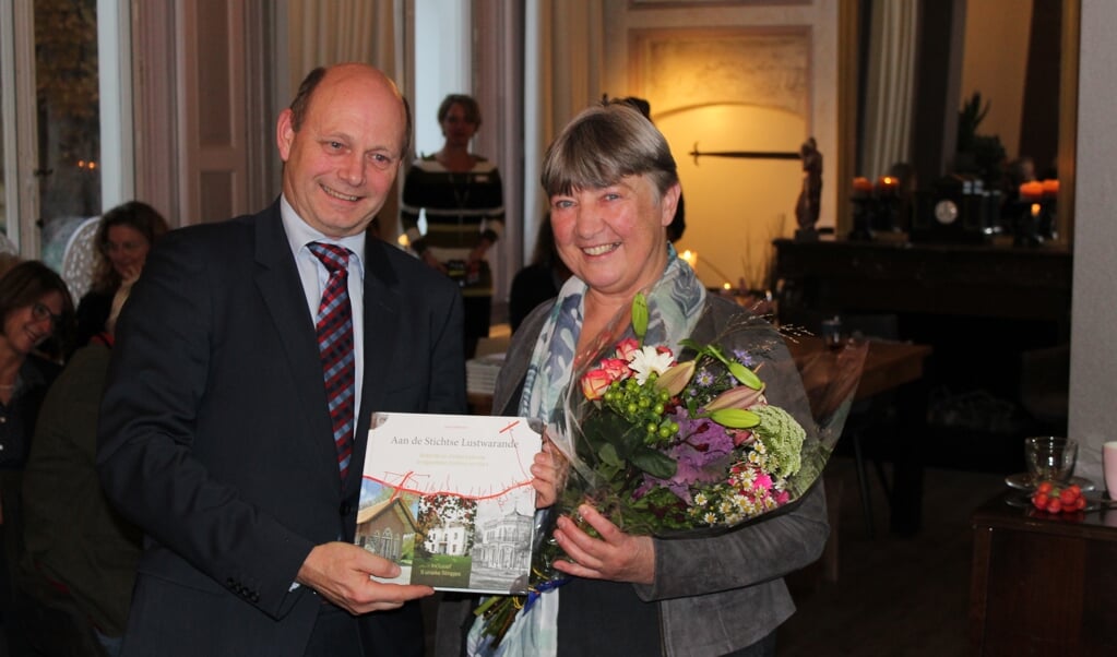 Loco-burgemeester Rob Jorg neemt het eerste exemplaar van het boek in ontvangst uit handen van auteur Annet Werkhoven.