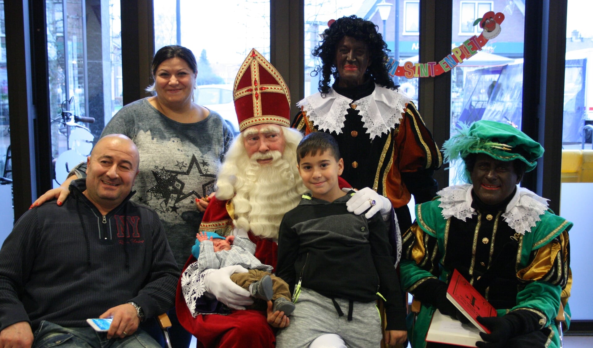 Sinterklaas met zwarte piet en een gelukkig gezin.